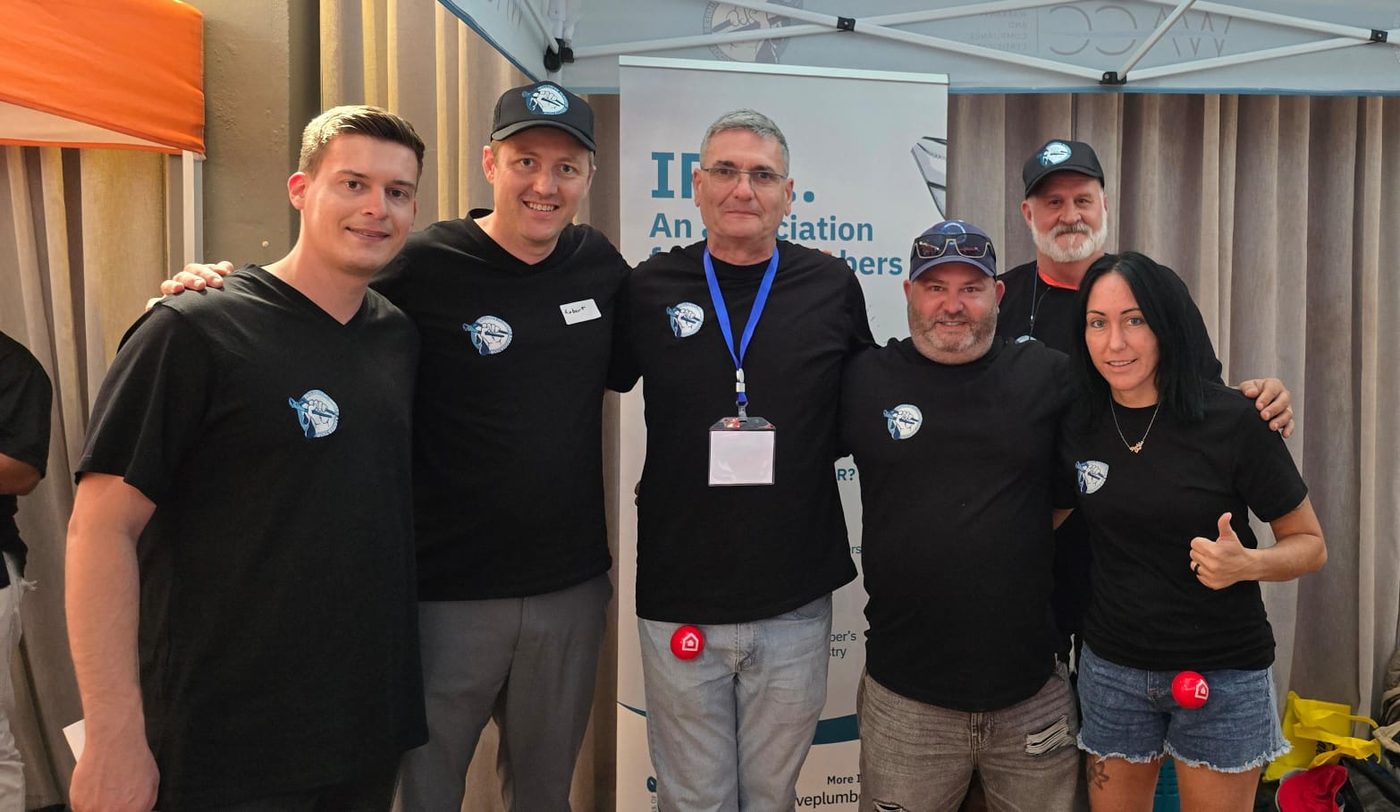 Members of the Inclusive Plumbers Association together at an association stand