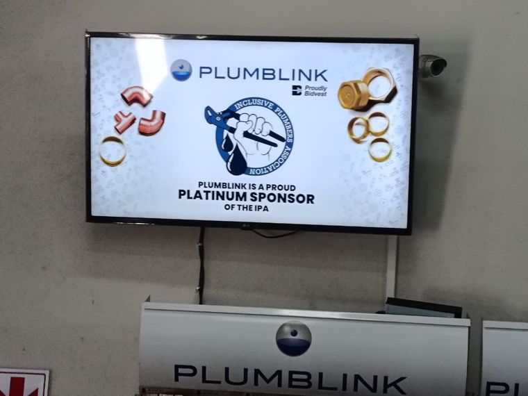 A screen in a plumbing merchant's branch showing that Plumblink is a proud platinum sponsor of the IPA