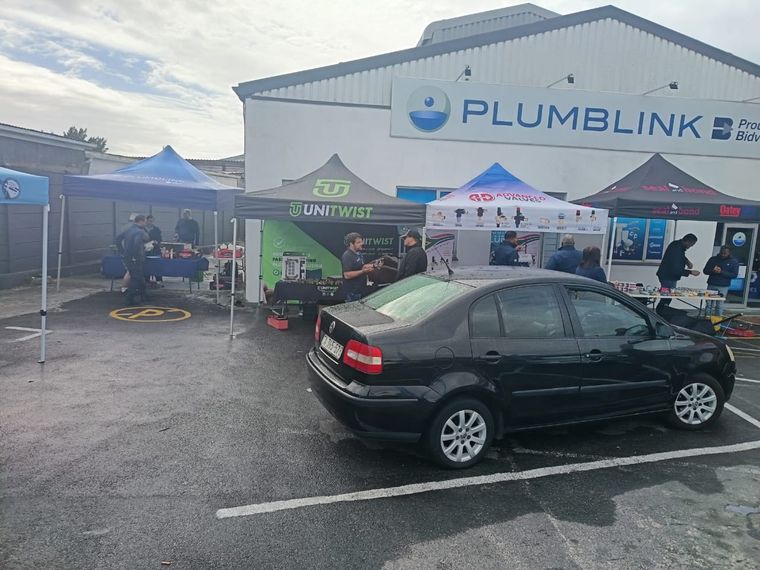 Unitwist, Advanced Valves and Seal and Bond stands set up in the parking area outside a Plumblink branch