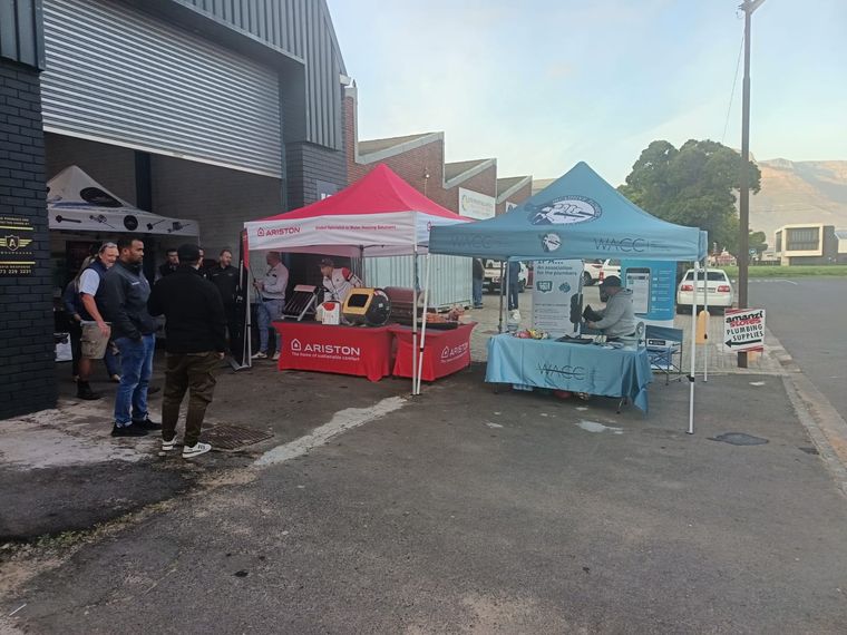 Plumbers talking between the Ariston and IPA stands at an outdoor trade day